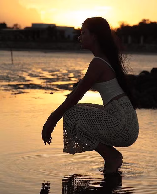 Người mẫu Thu Anh sử dụng chân váy lưới cùng crop-top và đồ bơi tiệp màu khi dạo biển.