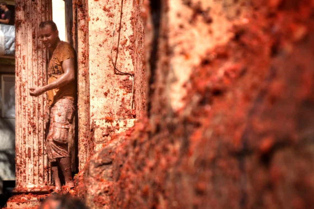 Các xe tải chở ngập cà chua chín vừa đi vừa trút chúng xuống đường.