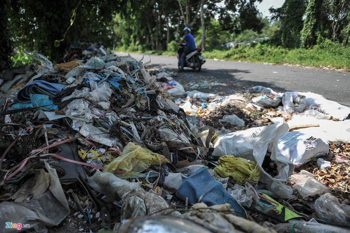 Con đường dẫn vào nhà máy rất nhếch nhác, rác thải chất đống hai bên đường.