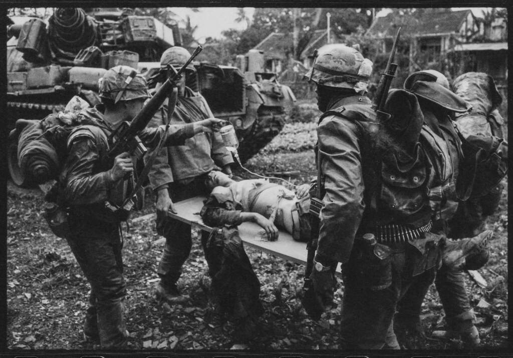 Lính Mỹ khiêng Blaine về chiếc xe tăng đang chờ gần đó.