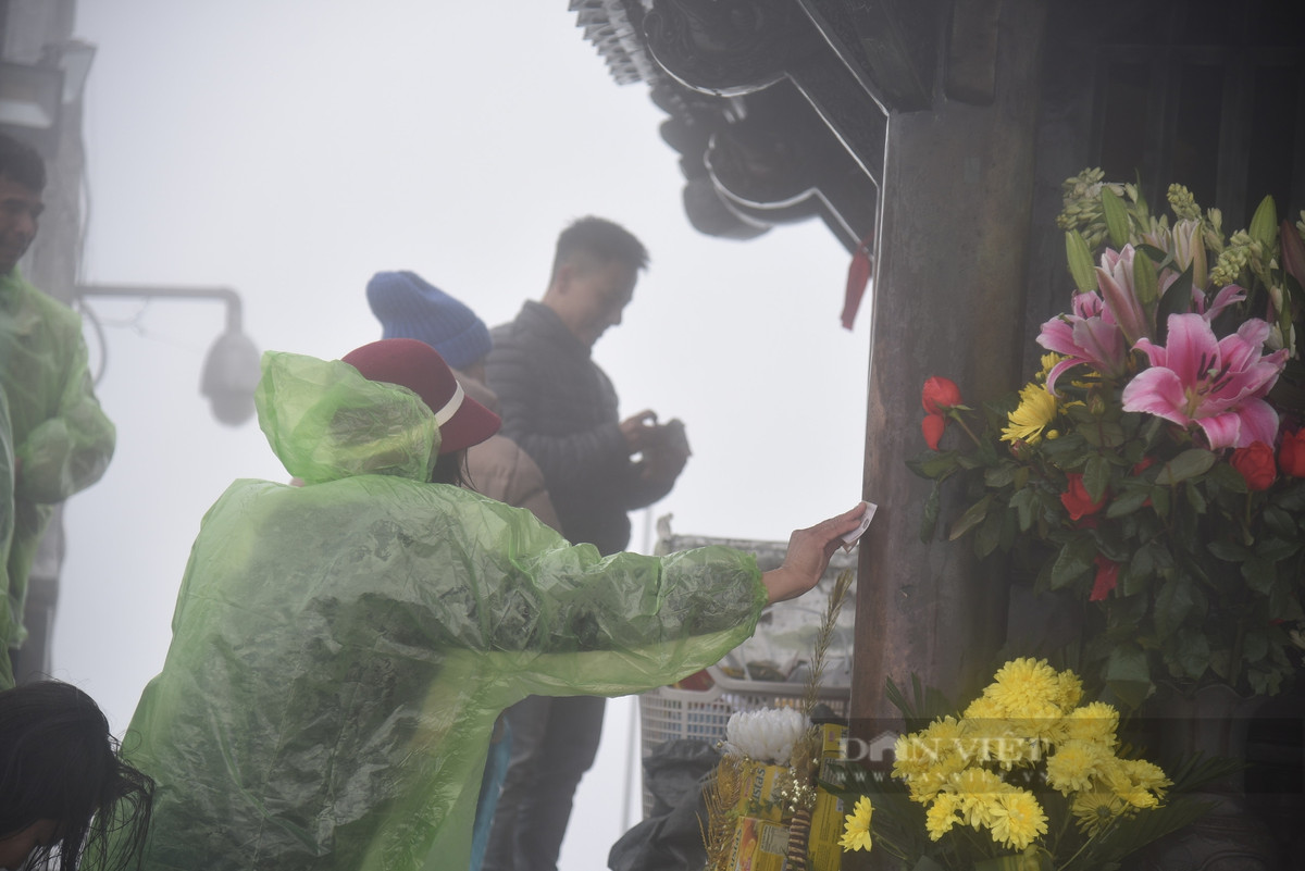 Nhiều du khách lấy tiền chà sát vào chùa Đồng, chuông, khánh trên đỉnh thiêng Yên Tử để cầu may.