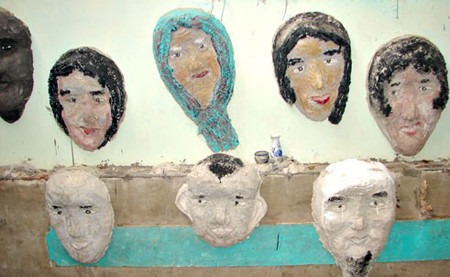 Trên vách nhà cũng có hàng loạt đầu người được treo lên.