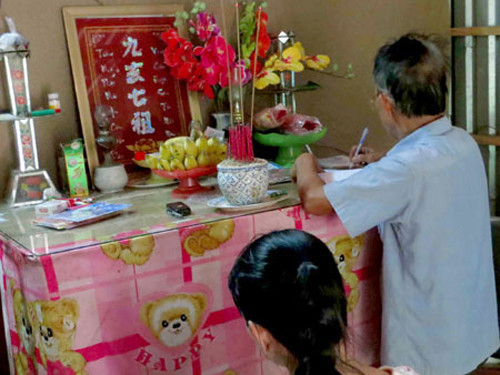 “Cậu tư” đứng trước bàn thờ xem bói cho khách.