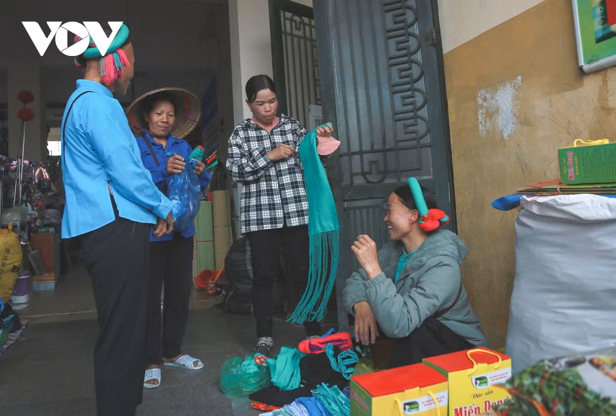 Các bà, các chị người Sán Chỉ tíu tít quanh gian hàng bán khăn, thử những tấm khăn vấn đầu mới để đón Tết