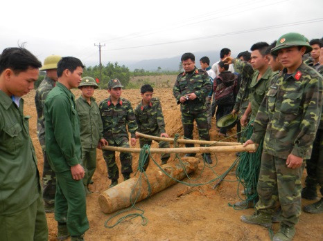 Ngày 17/2/2014, Đội rà phá bom mìn thuộc Trung tâm Xử lý bom mìn Trường Sơn - Binh đoàn 12 đã phát hiện và đào bốc một quả bom nặng 200kg trong bãi đất gần khu dân sinh sống thuộc thôn Tân Sơn, xã Sơn Hóa, huyện Tuyên Hóa, tỉnh Quảng Bình. Quả bom nằm cách mặt đất khoảng 50cm, cắm theo chiều thẳng đứng. Ảnh: Đài TH Quảng Bình.