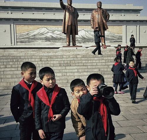 Trẻ em vui đùa dưới tượng đài hai cựu lãnh tụ Kim Nhật Thành và Kim Jong Il.