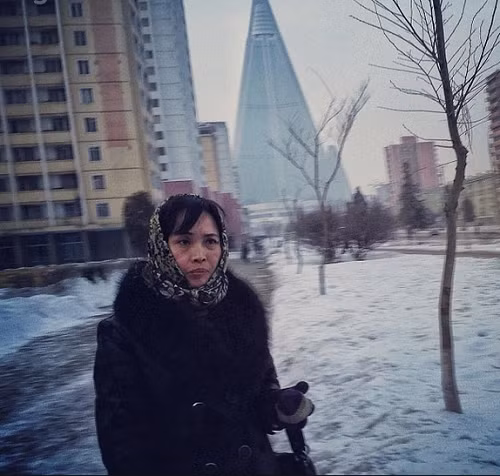 Người phụ nữ đứng trước tòa khách sạn cao 105 tầng đang thi công.