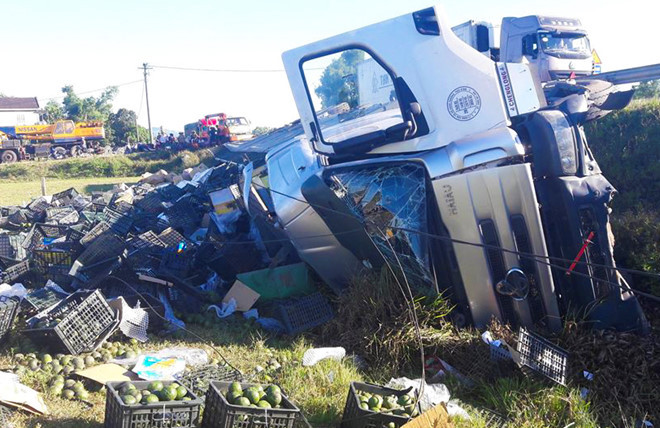 Chiếc xe tải lật nghiêng bên vệ đường. Ảnh: Phan Hoài.