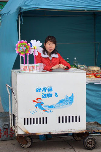 Cô bán hàng ngồi ngay ngắn bên sạp hàng tạp hóa nhỏ trong sở thú.