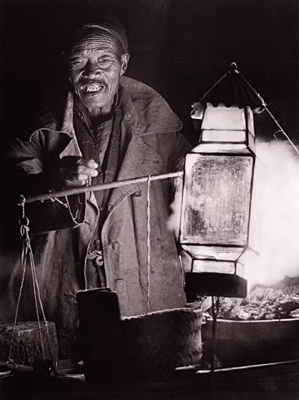 Người đàn ông Trung Quốc với gánh hàng rong buổi tối.