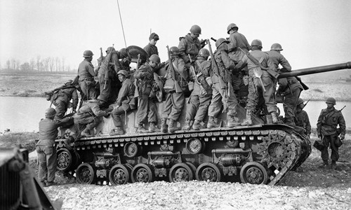 Hàng chục binh sĩ Mỹ leo lên một chiếc xe tăng khi vượt sông Hongchon ngày 14/3/1950.