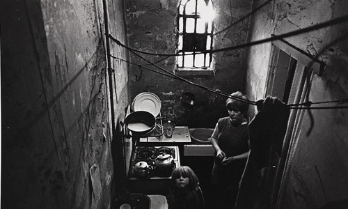 Người phụ nữ và con nhỏ ngước nhìn từ nhà bếp trong khu ổ chuột ở Balsall Heath, Birmingham vào tháng 10/1969.