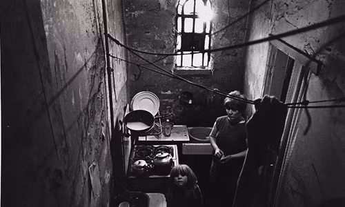 Người phụ nữ và con nhỏ ngước nhìn từ nhà bếp trong khu ổ chuột ở Balsall Heath, Birmingham vào tháng 10/1969.