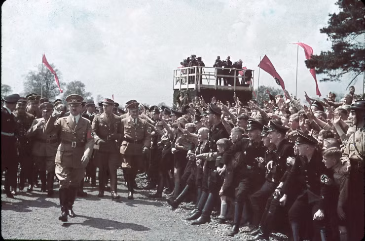Đám đông đứng hai bên đường chào đón Hitler khi trùm phát xít tham dự buổi lễ tại nhà máy Volkswagen năm 1938.