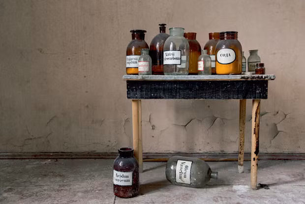 Những lọ hóa chất được đặt trên bàn, một số nằm chỏng chơ dưới đất trong tòa nhà bỏ hoang.