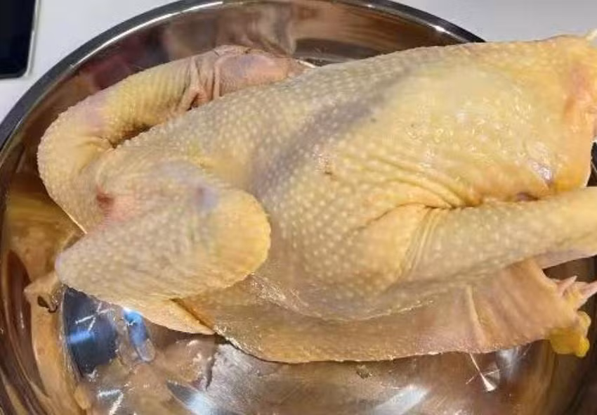  Cách làm: Xử lý và rửa sạch. Cho nước vào nồi, cho hành, gừng vào đun sôi. Sau khi nước sôi, vặn nhỏ lửa và ngâm gà thật kỹ. Khi bạn cắm đũa vào chân gà, nếu không chảy máu là đã chín. 