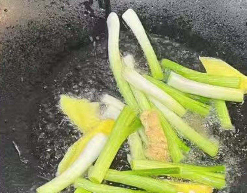  Đun nóng dầu trong chảo, cho hành và gừng vào xào cho đến khi có mùi thơm. Cho thịt ba chỉ vào xào đến khi có mùi thơm. 