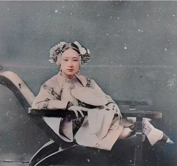  Khuôn mặt của người phụ nữ này trông rất phóng khoáng. Cô có một dáng người nhỏ nhắn và thanh tú. Đánh giá từ trang sức cài trên đầu và chiếc quạt trên tay, cô gái này hẳn là một tiểu thư chưa chồng, xuất thân từ một gia đình giàu có.