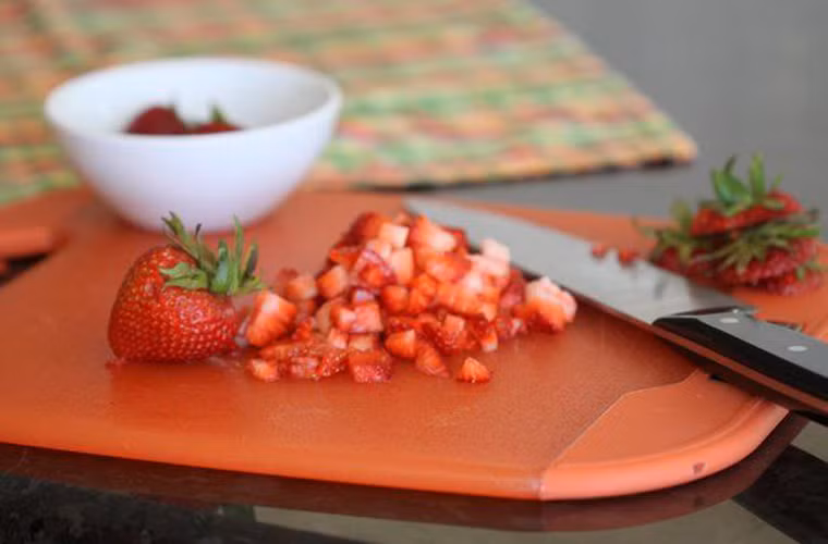 Sau đó, dùng dao cắt nhỏ dâu ra thành nhiều miếng nhỏ.