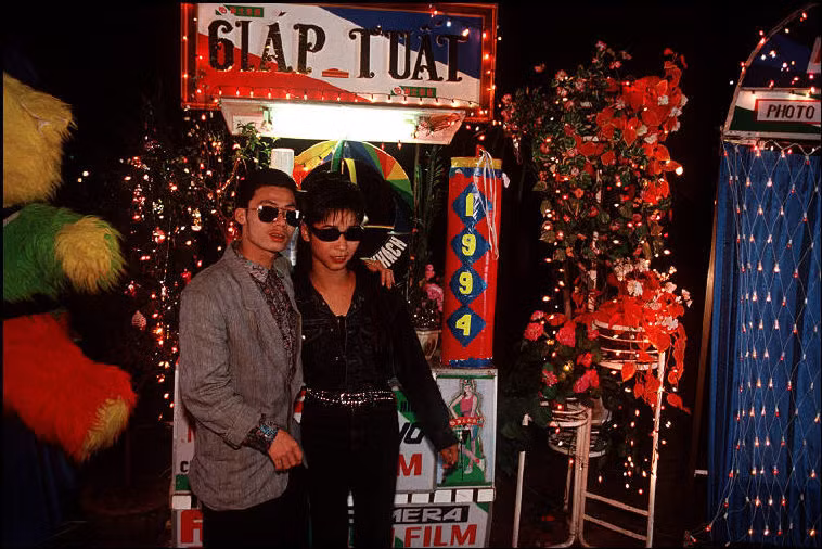 Hai thanh niên mặc Âu phục tạo dáng chụp ảnh ở bờ hồ Hoàn Kiếm dịp Tết Giáp Tuất năm 1994. Ảnh: Bruno Barbey/Magnum.