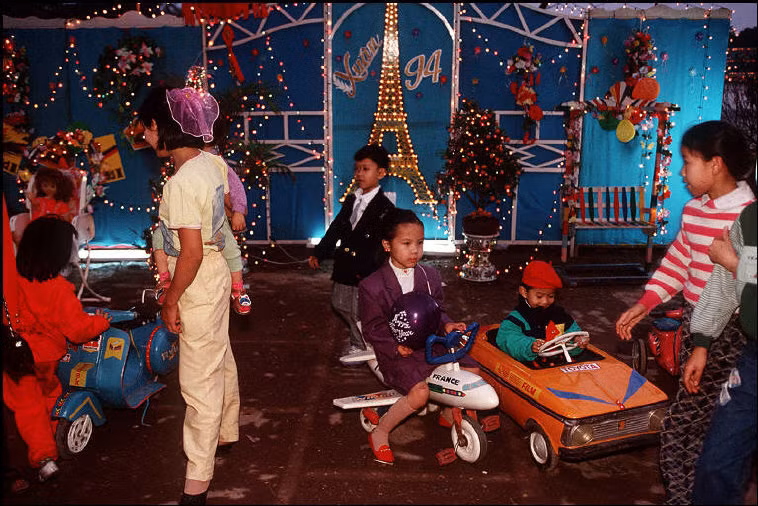 Trẻ em vui chơi ở bờ hồ ngày Tết Hà Nội năm 1994. Ảnh: Bruno Barbey/Magnum.