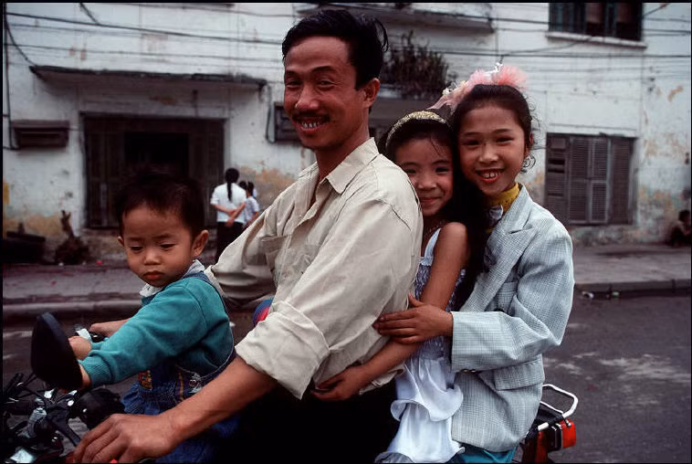 Ông bố đưa đàn con đi chơi Tết bằng xe máy. Ảnh: Bruno Barbey/Magnum.