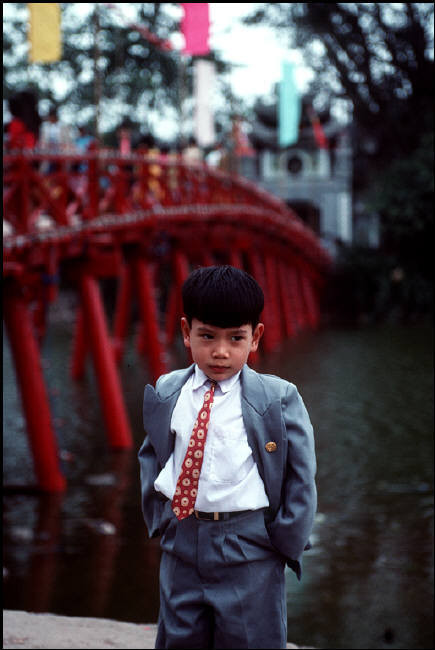 Cậu bé đứng cạnh cầu Thê Húc khi đi chơi Tết nguyên đán cùng gia đình. Ảnh: Bruno Barbey/Magnum.