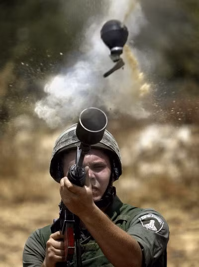 12. Một cảnh sát biên giới Israel bắn hộp đạn hơi cay vào người biểu tình Palestine chống lại việc xây dựng các hàng rào an ninh gây tranh cãi ở bờ Tây Az - Zawiya của Israel ngày 20/6/2004.