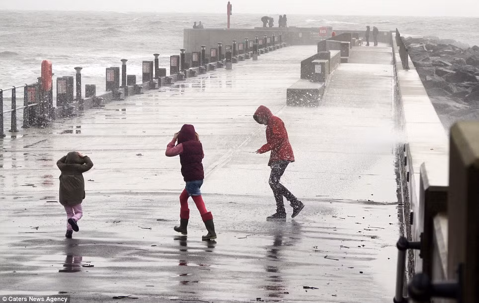 Vài trẻ em chạy bão ở Vịnh Tây thuộc Dorset, chỉ cách Lyme Regis, nơi một phóng viên ảnh bị nghi bị sóng lớn do bão đánh trôi ra biển.