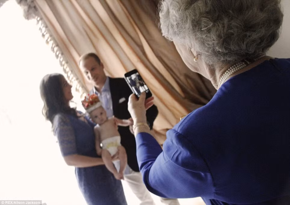 Thậm chí, nghệ sĩ Alison Jackson còn tưởng tượng ra cảnh Nữ Hoàng Elizabeth II dùng điện thoại chụp ảnh vợ chồng chắt nội.