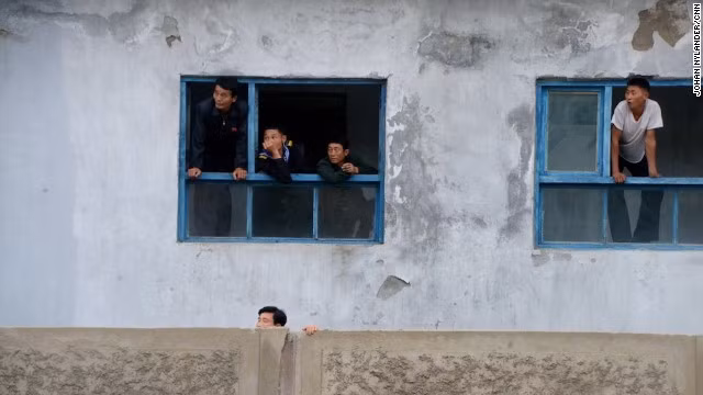 Tuy nhiên, lời hứa hẹn mà nhà báo Thụy Điển nhận được cuối cùng không được thực hiện. Trong ảnh, người dân thành phố Rason ló đầu ra ngoài cửa số xem cuộc đua xe đạp quốc tế.