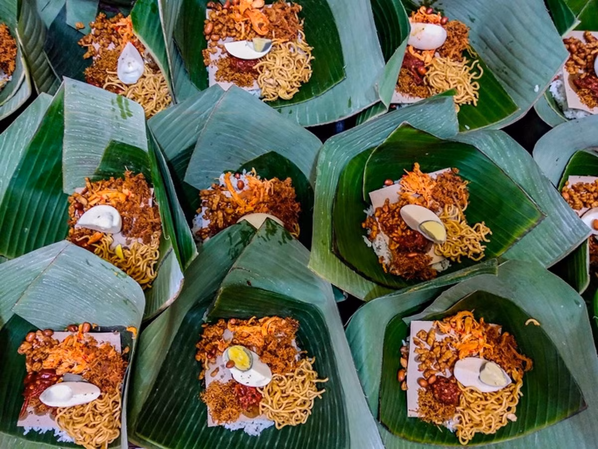 Món Nasi Jinggo: Món Nasi Jinggo còn được gọi là Nasi Jenggo. Những gói cơm nhỏ, tiện lợi này đi kèm với nhiều món ăn kèm khác nhau như gà xé, mì xào, thịt, cá hoặc trứng. Cơm có thể có màu trắng hoặc vàng, mang lại cảm giác bắt mắt và thơm ngon hơn. Nguồn: Detik