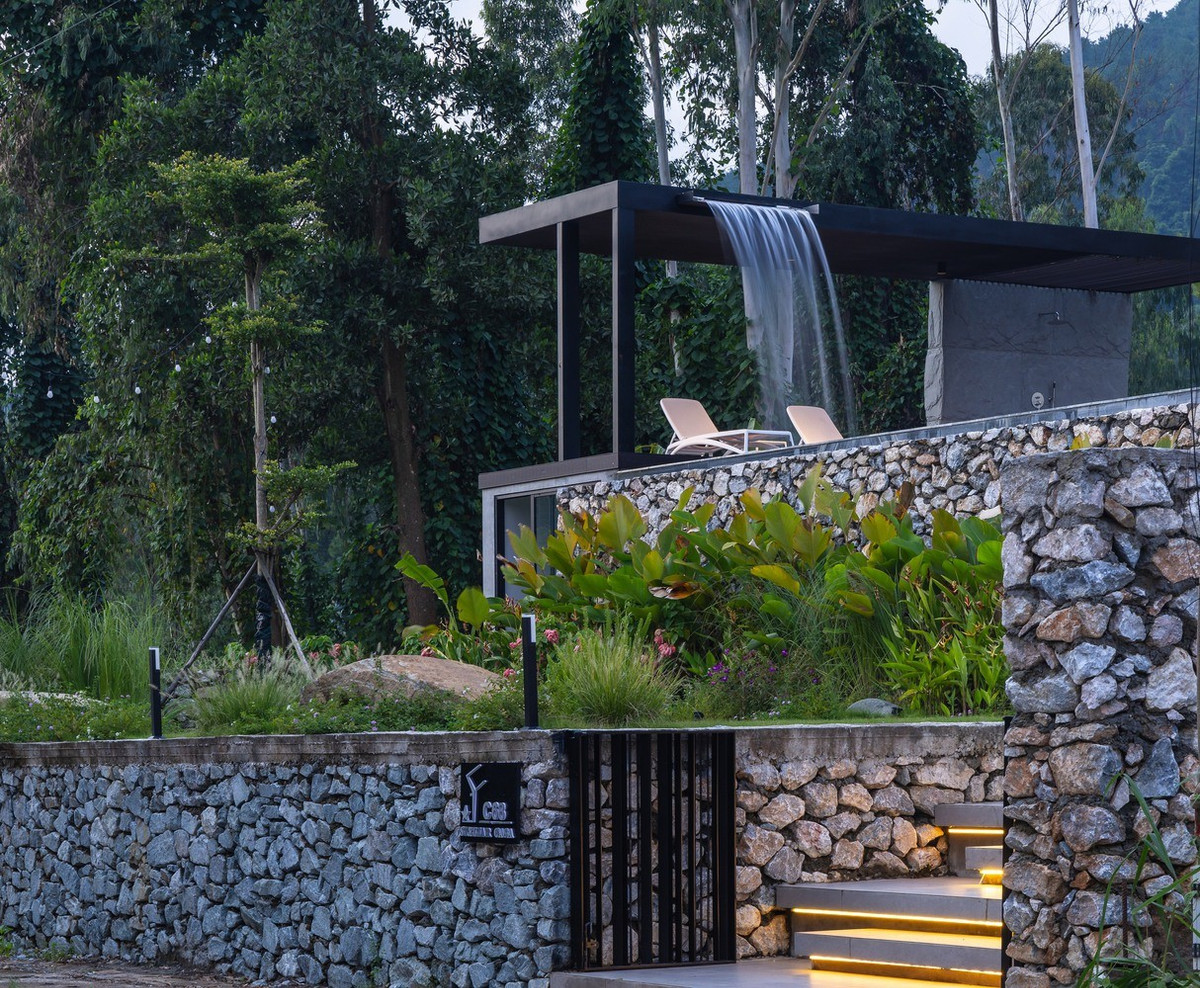 Một hồ bơi lớn với thác nước ấn tượng chiếm vị trí nổi bật ở phía trước biệt thự, vừa là trung tâm thị giác vừa là nơi nghỉ ngơi ngoài trời sang trọng. Hồ bơi được thiết kế để hòa nhập liền mạch vào cảnh quan xung quanh, tạo ra không gian thanh bình để thư giãn và giải trí.