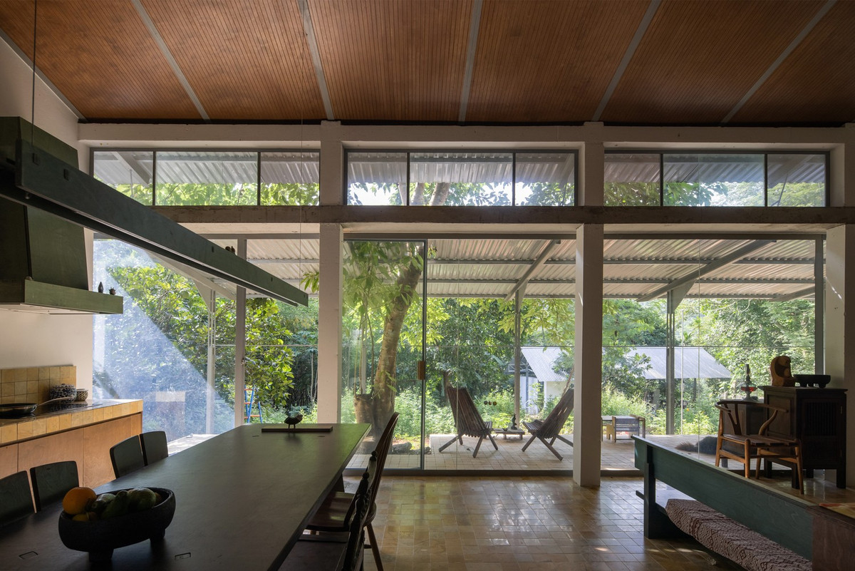 Không gian sinh hoạt chung bao gồm phòng khách, khu vực ăn uống, bếp và sân chơi, được kết nối trực tiếp với hiên nhà và khu vườn.