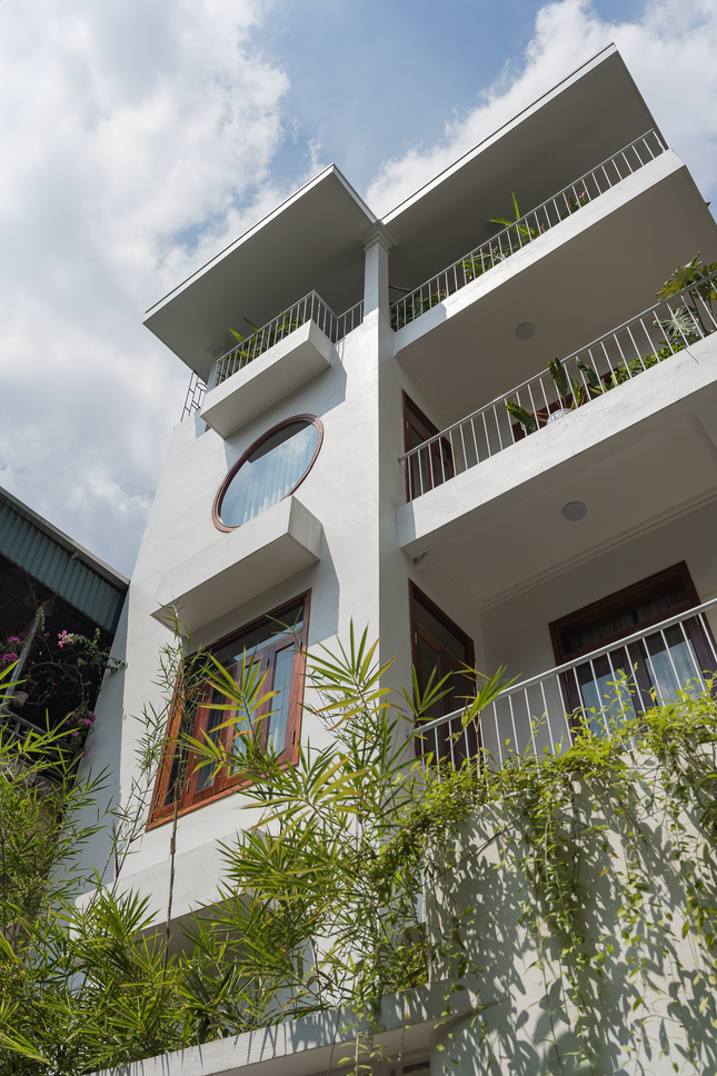 Hai bên phía hàng rào tường được bố trí các bồn trồng trúc, vừa giúp ngăn cách không gian với những nhà xung quanh vừa tạo không gian xanh. Nhấn nhá thêm khu vực tường cổng là gạch thông gió và gạch ốp lát hoạ tiết.