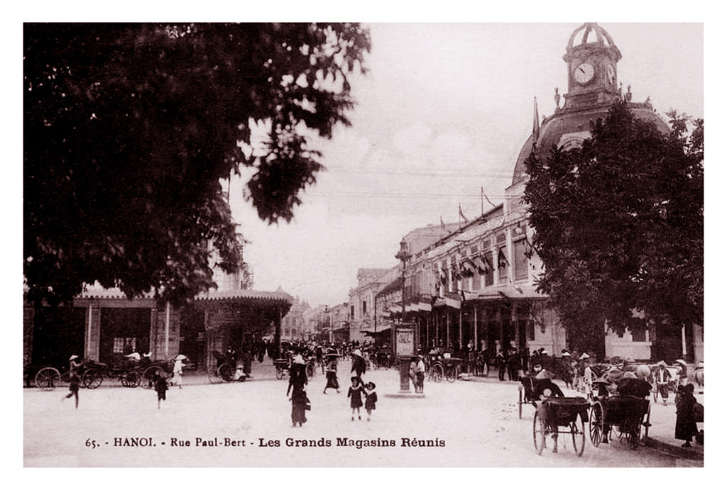 Phố Paul Bert và thương xá Grands Magasins khoảng thập niên 1920. Từ một nơi chuyên bán hàng hóa cao cấp, vào thời bao cấp, Bách hóa Tổng hợp bán chủ yếu quần áo, vải vóc, phục tùng xe đạp... theo tem phiếu.