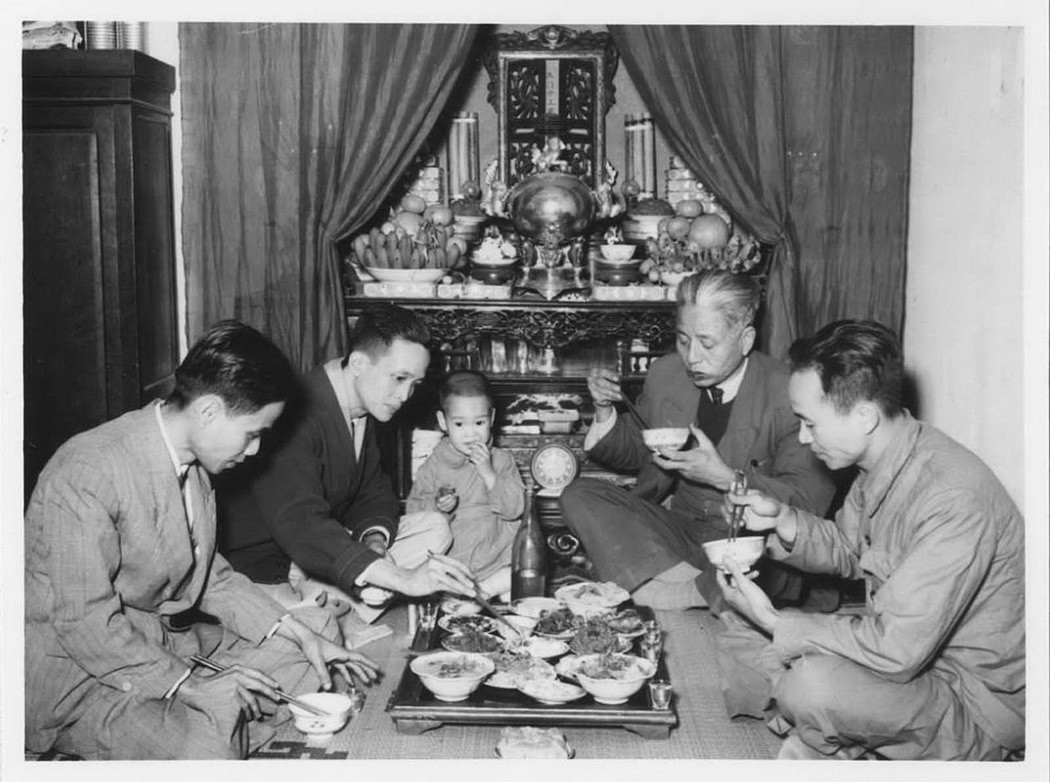 Bữa ăn bên bàn thờ gia tiên. Đồ ăn bày trên mâm gỗ, trước đó đã được cúng trên bàn thờ.