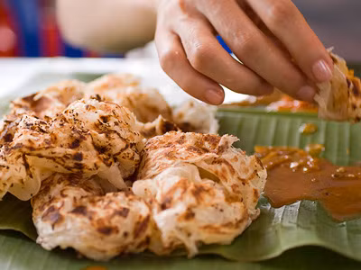 Khi ăn bánh bạn nên dùng tay bốc, những chiếc bánh được xé thơm mùi bột, ăn kèm cùng cà ri gà sẽ khiến bạn suýt xoa liên tục.