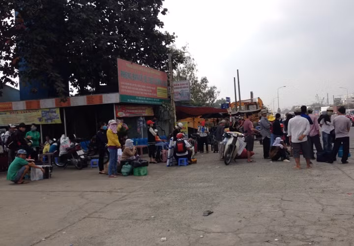 Dọc tuyến Quốc lộ 1A ở cửa ngõ phía Đông Bắc thành phố, hàng trăm người đứng dọc đường chờ đón xe để về quê