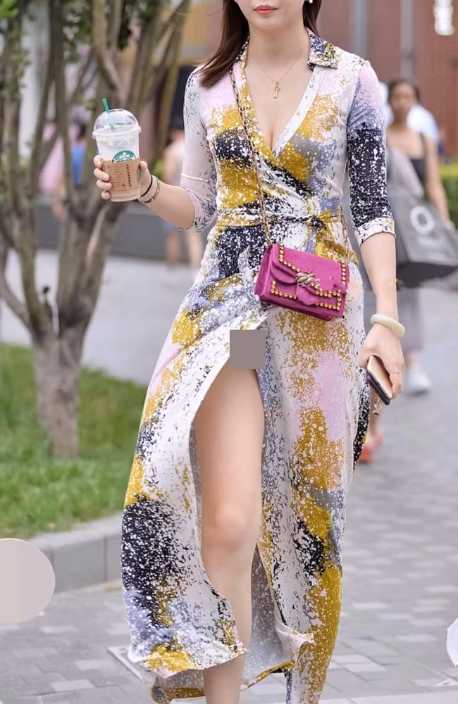 Chiếc váy lụa có đường xẻ cao hun hút khiến người đẹp bị hớ hênh nhưng chẳng hay biết gì.