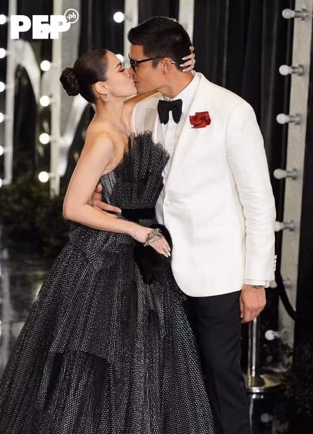 Marian Rivera và chồng trao cho nhau nụ hôn ngọt ngào. Hai diễn viên đã bên nhau 11 năm, có hai nhóc tỳ Zia và Sixto, nhưng vẫn giữ được tình cảm mặn nồng như khi mới yêu. Họ được gọi là nhà vua và nữ hoàng của buổi tiệc.