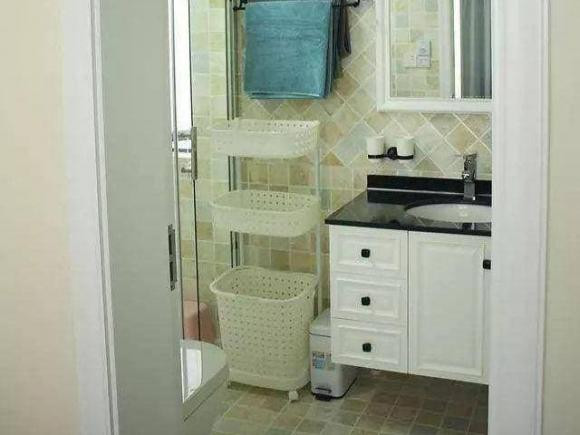 Đây là phòng tắm chính, sàn và tường được ốp gạch giống như tường bếp, màu sắc tương đối phong phú, nhìn khá đẹp. Giỏ đựng đồ bên cạnh bồn rửa được thiết kế ba chiều và không chiếm quá nhiều diện tích.