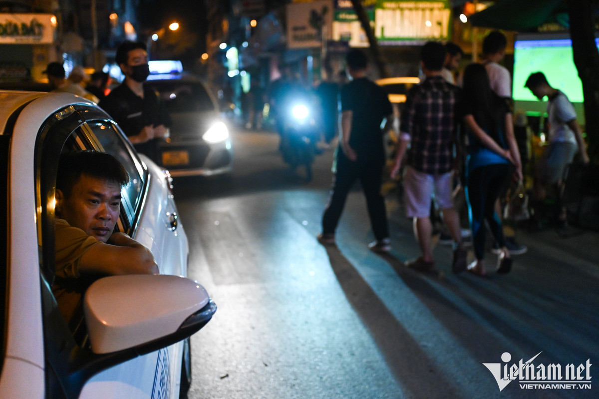 Anh Đỗ Quýnh (lái xe taxi) cũng dừng lại bên đường, tranh thủ "hóng" trận đấu giữa đội chủ nhà Quatar và Ecuador qua màn hình máy chiếu của một quán cà phê. Lúc này đã là 0h30, nhiều hàng quán đóng cửa muộn hơn mọi ngày để đón khách.