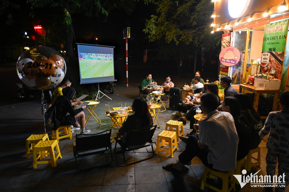 Tại ngã tư Vạn Phúc - Vạn Bảo (quận Ba Đình), một quán nước vỉa hè thu hút khá đông khán giả ngồi xem trận đấu khai mạc. Chủ quán cho biết, đã đầu tư tiền thuê màn chiếu, vừa để thu hút khách đồng thời ông cũng tiện theo dõi do là người hâm mộ môn thể thao vua.