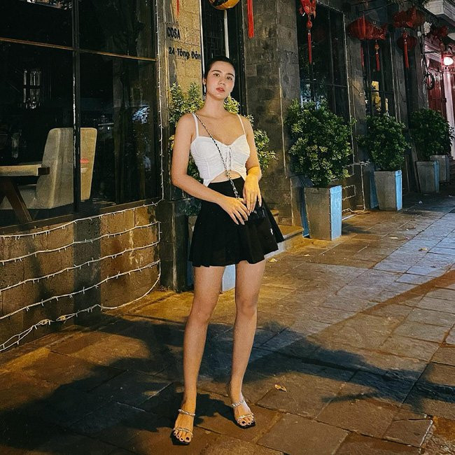 Áo crop top trắng + chân váy chữ A + sandal của Huyền Lizzie mang toàn gam màu trung tính, nhưng siêu nổi bật khoe được vòng eo mi nhon và bờ vai nuột nà. Ngoài vẻ sexy, outfit này cũng rất trẻ trung, ngọt ngào.