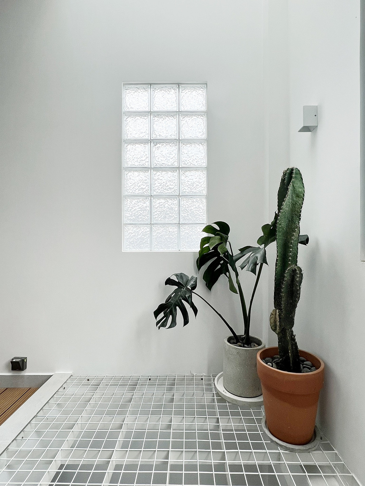 Anh Linh chia sẻ, cái khó của nhà ống là chỉ có một mặt thoáng nên anh lo nhất bị tối, bí. Vì vậy, anh tính ánh sáng rất kĩ, đặt giếng trời ở đâu, cửa sổ ở đâu để ánh sáng mặt trời rọi xuống tốt nhất. Phần tường tiếp giáp với giếng trời anh dùng gạch kính lấy sáng, tăng khoảng sáng cho không gian.