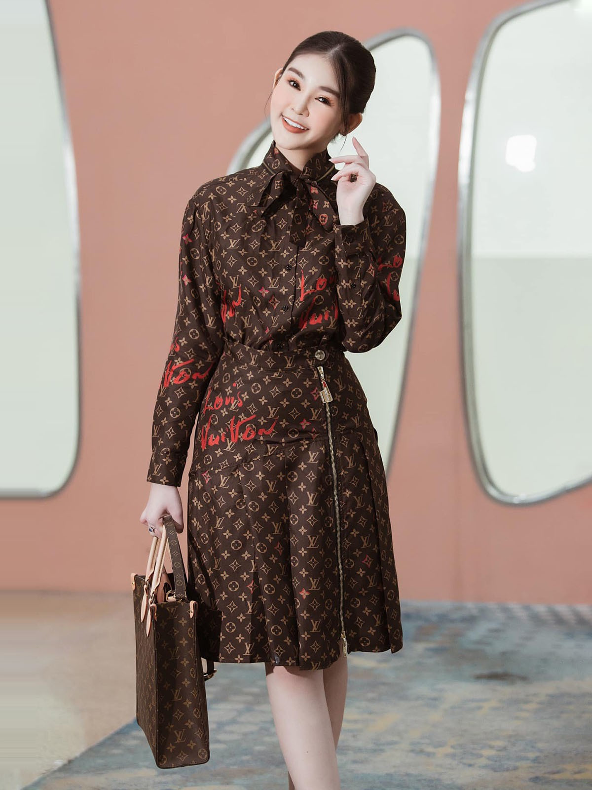 Bộ váy áo họa tiết monogram được nàng hậu kết hợp cùng túi Sac Plat 2.640 USD (63 triệu đồng).