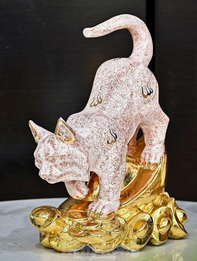 Chủ cửa hàng Vân Anh tại chợ gốm Bát Tràng cho biết, trong phong thủy, mèo thần tài có thể hóa giải sát khí, vẫy gọi tiền bạc vào nhà. Mèo gốm dát vàng còn được gọi là linh thú cát tường, mang lại may mắn cho gia chủ, hy vọng một năm mới bình an, thịnh vượng.