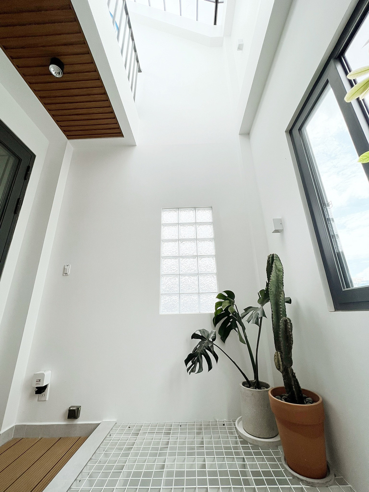 Anh Linh chia sẻ, cái khó của nhà ống là chỉ có một mặt thoáng nên anh lo nhất bị tối, bí. Vì vậy, anh tính ánh sáng rất kĩ, đặt giếng trời ở đâu, cửa sổ ở đâu để ánh sáng mặt trời rọi xuống tốt nhất. Phần tường tiếp giáp với giếng trời anh dùng gạch kính lấy sáng, tăng khoảng sáng cho không gian.