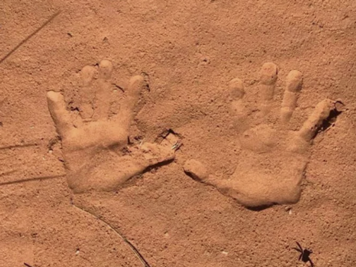 Chỉ là những dấu tay nhưng trông giống như bàn tay nhô lên từ cát